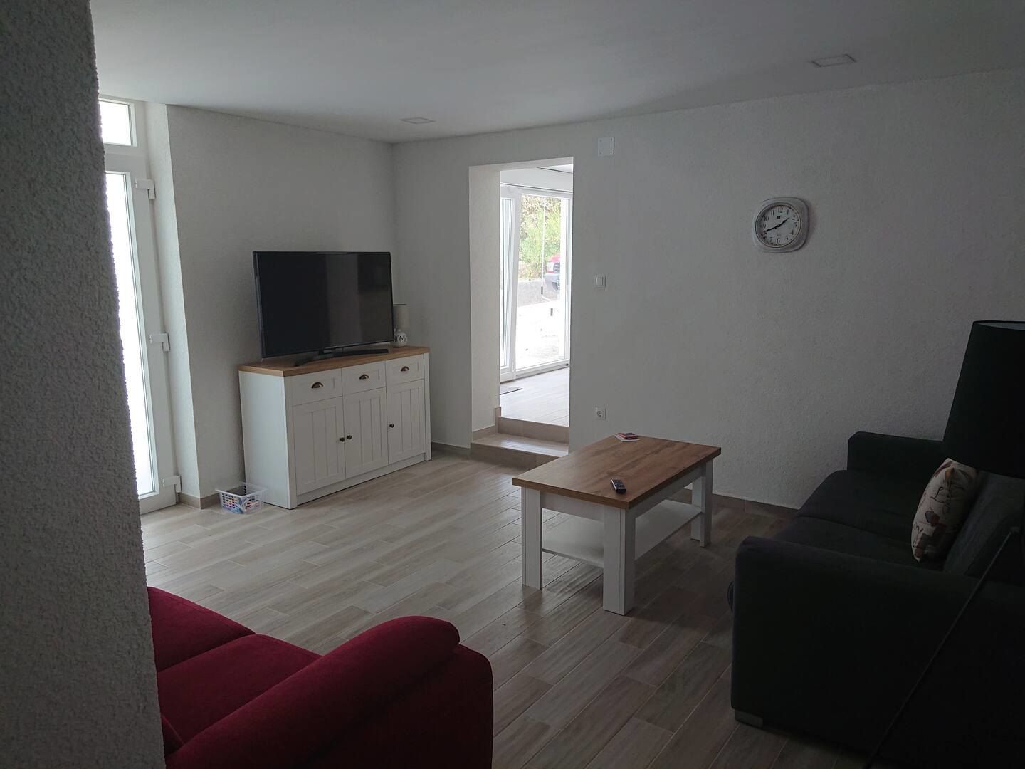 Living room with a television, coffee table and doors to the terrace