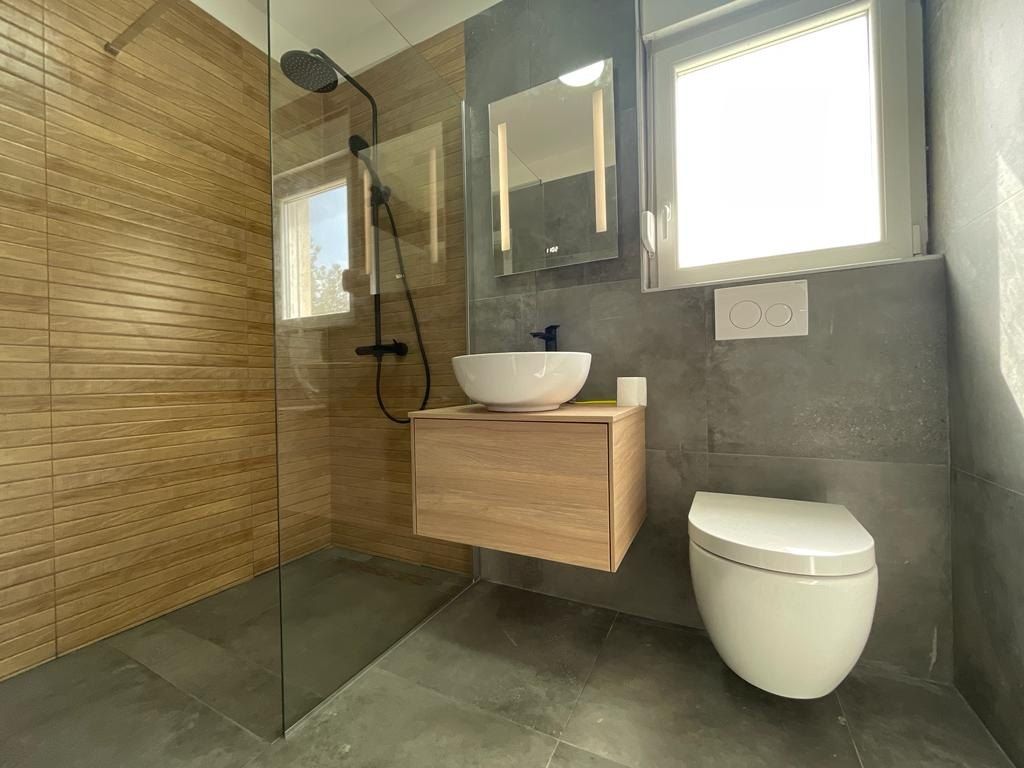 Bathroom with a glass walk-in shower and wall-hung toilet