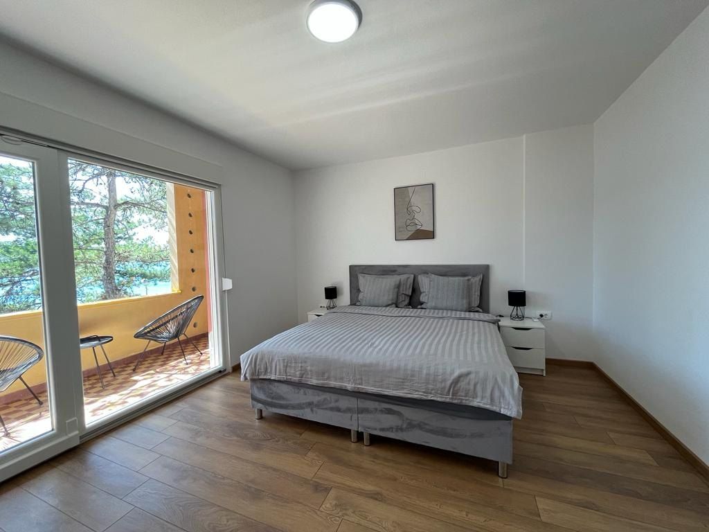 Second bedroom with a queen-size bed and glass doors to the balcony
