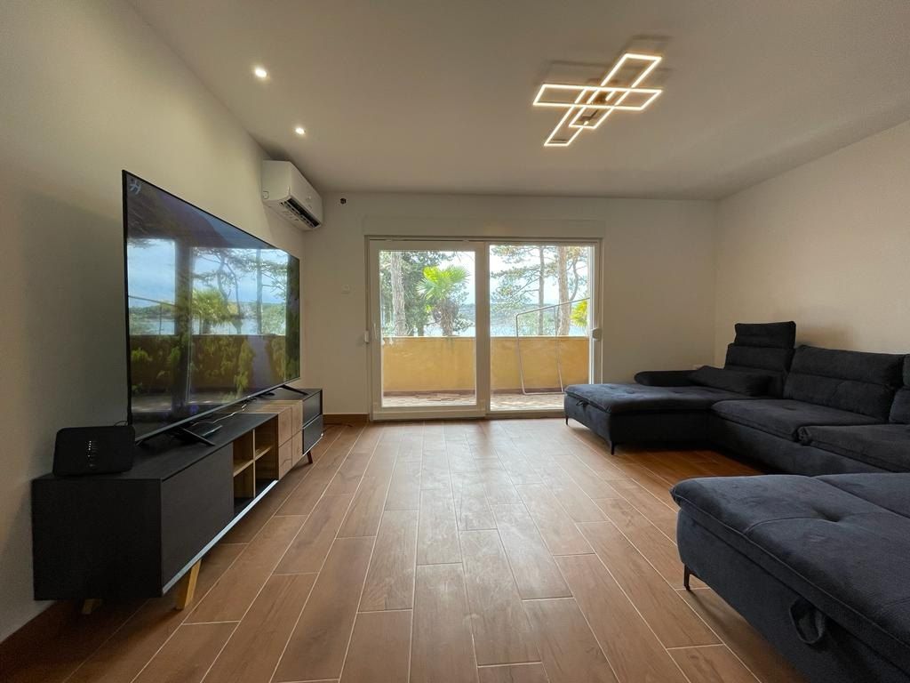 Living room with a wall-mounted television and a corner sofa